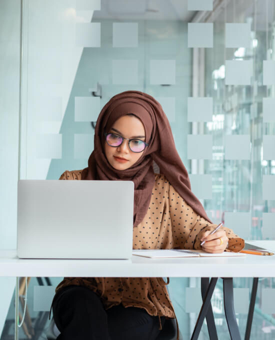 Woman in hijab working from laptop